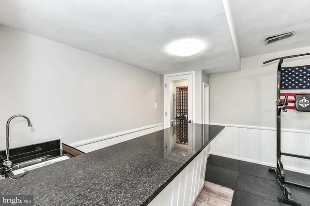 a bathroom with a granite countertop sink a toilet a mirror and shower