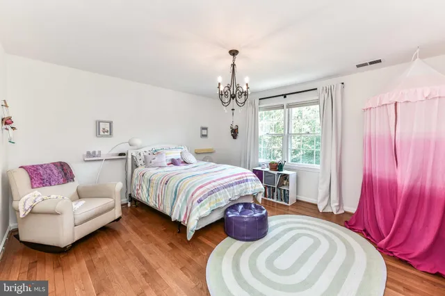 a spacious bedroom with a bed and a dresser