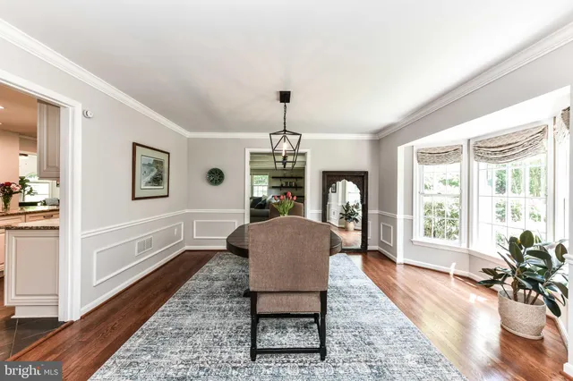 a dining room with furniture a chandelier and wooden floor