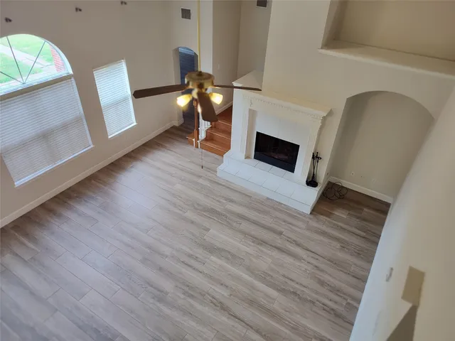 a view of a livingroom with wooden floor and a fireplace