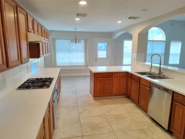 a kitchen with a sink a stove and cabinets