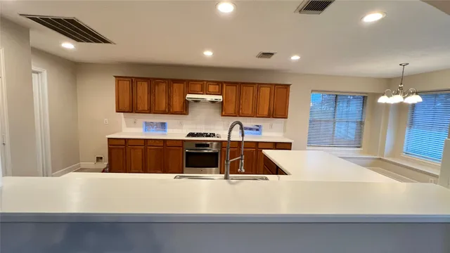 a large white kitchen with wooden floors and a stove