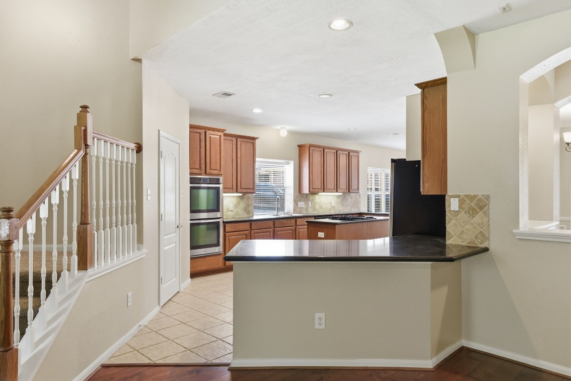 3414 Hackberry Court Spring, TX 77388 - Photo 14 of 50 Let's check out this awesome kitchen! Granite counter tops, tile backsplash, stainless steel appliances, gas cooktop!