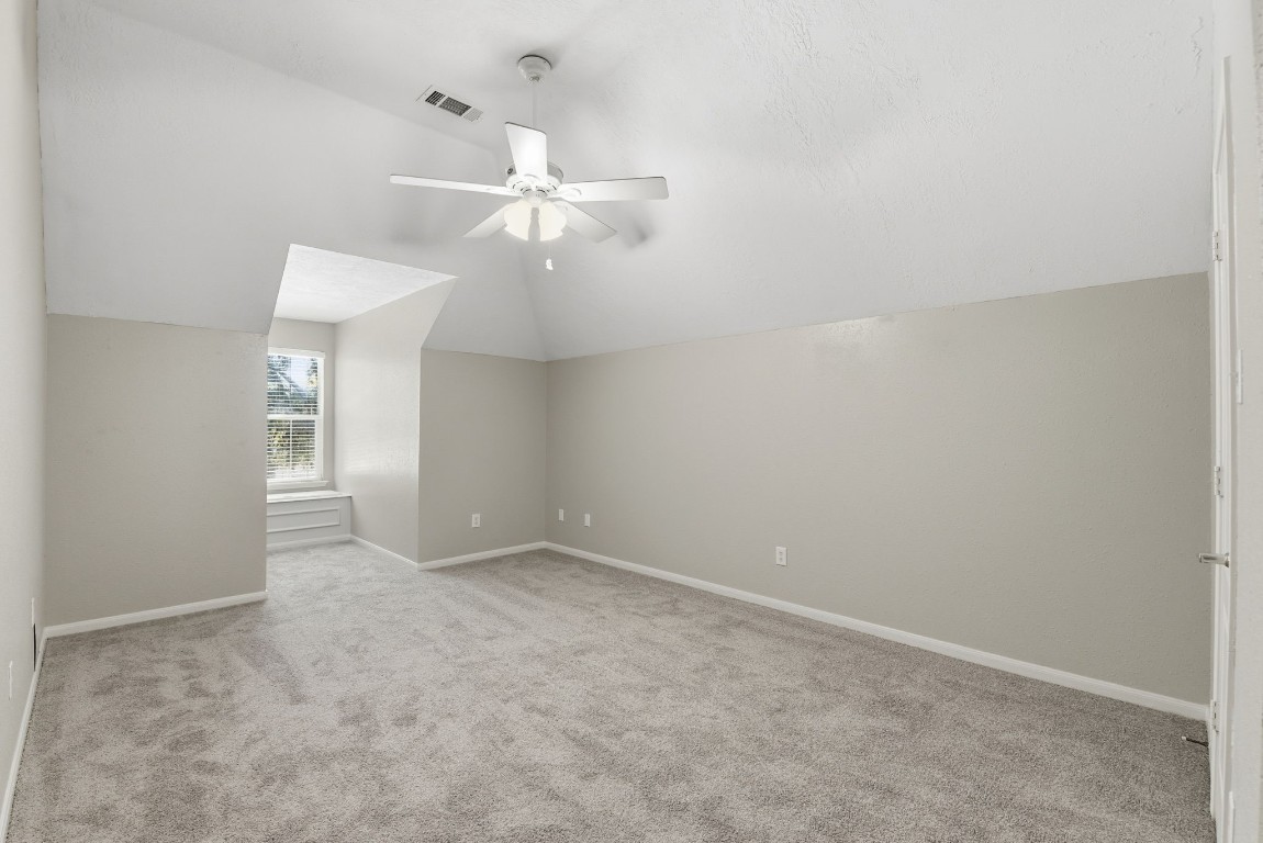 3414 Hackberry Court Spring, TX 77388 - Photo 37 of 50 Secondary bedroom upstairs with a storage box in the dormer window area. Fresh paint, carpet replaced April 2026, ceiling fan.