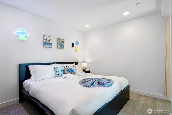 a bedroom with a bed and painting on the wall