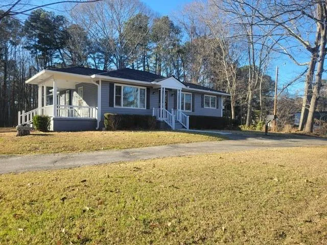 a front view of house with yard and trees around