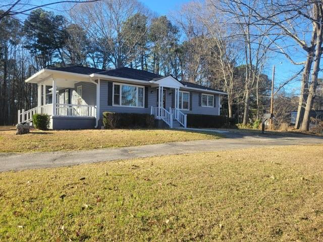 5012 Suwanee Dam Road Suwanee, GA 30024 - Photo 2 of 13 a front view of house with yard and trees around