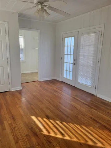 a view of an empty room with a window and wooden floor