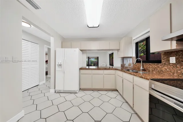 a kitchen with white cabinets and appliances