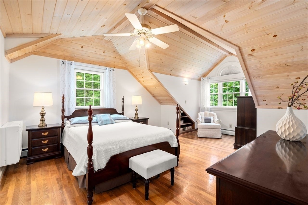 19 Brady Loop Andover, MA 01810 - Photo 19 of 35 a bedroom with a bed a table and chair with the large mirror