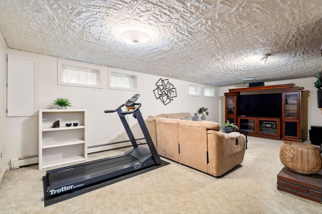 19 Brady Loop Andover, MA 01810 - Photo 26 of 35 a living room with furniture gym equipment and a flat screen tv