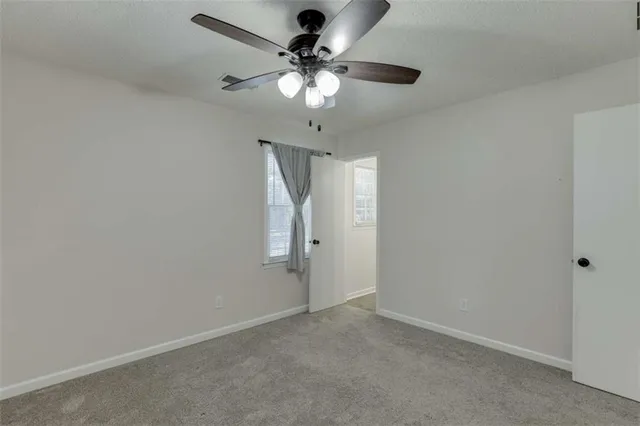 a view of an empty room with a chandelier fan