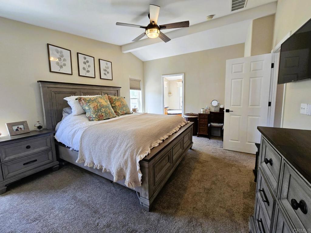2239 Black Canyon Road, Unit 55 Ramona, CA 92065 - Photo 25 of 38 a spacious bedroom with a bed and a chandelier