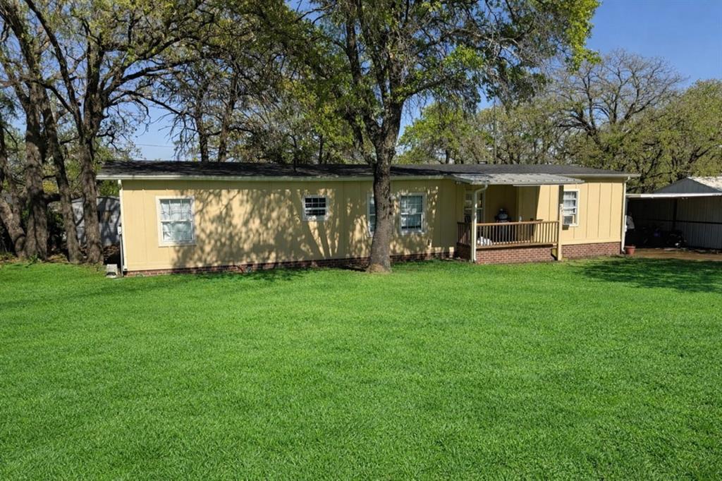 Rear view of house featuring a deck and a lawn