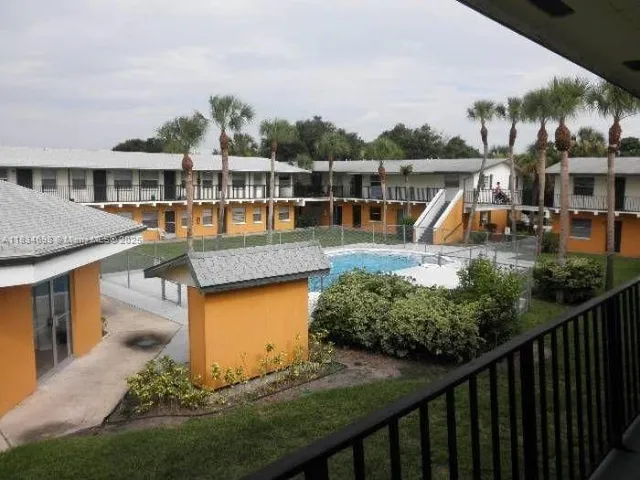 a view of a house with pool and chairs