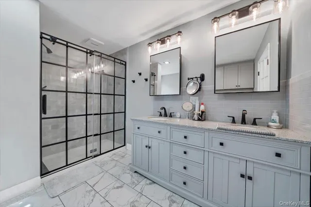 a bathroom with a granite countertop sink vanity mirror next to a cabinet