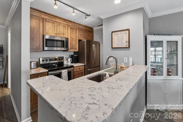 a kitchen with stainless steel appliances granite countertop a sink a stove and a refrigerator