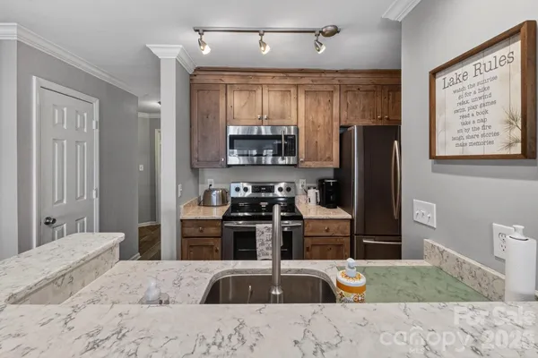 a kitchen with kitchen island a refrigerator stove and sink