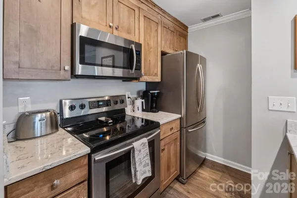 a kitchen with stainless steel appliances granite countertop a stove microwave and refrigerator