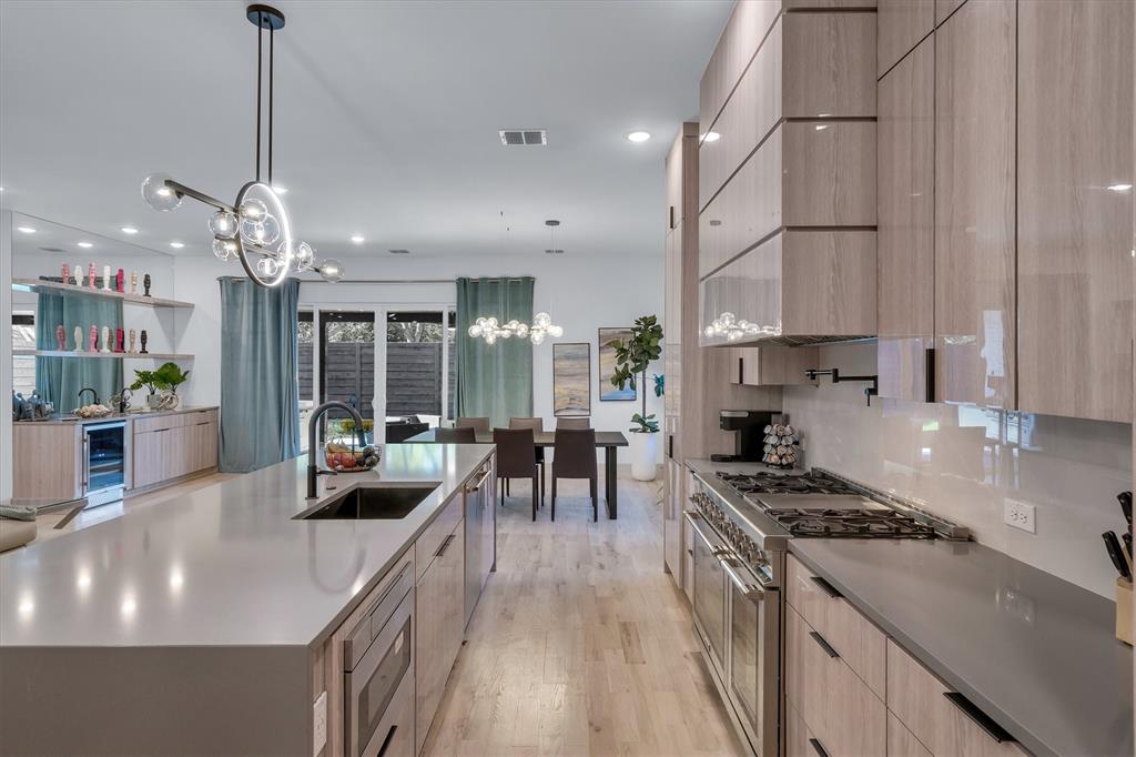 7519 Robin Road Dallas, TX 75209 - Photo 22 of 40 a kitchen with stainless steel appliances a stove a sink a counter top space and living room view