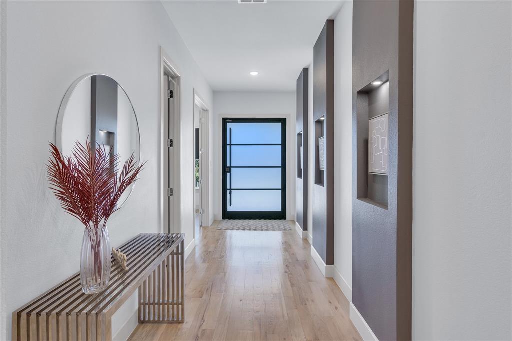 7519 Robin Road Dallas, TX 75209 - Photo 3 of 40 a view of a hallway with wooden floor and a chandelier