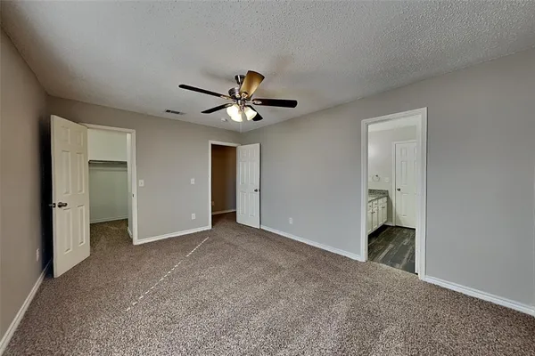 an empty room with a ceiling fan and a window