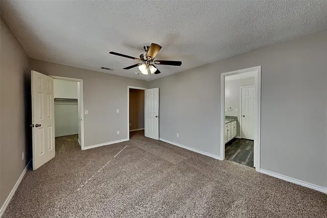 an empty room with a ceiling fan and a window