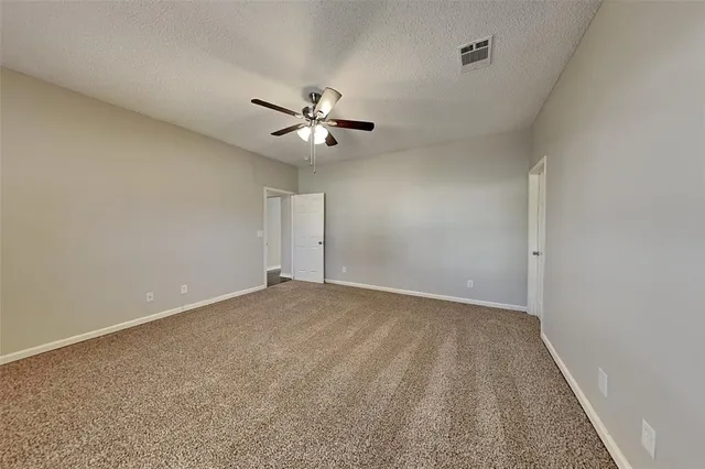 an empty room with a ceiling fan and wooden floor