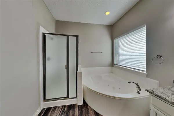 a bathroom with a tub a sink and a large mirror