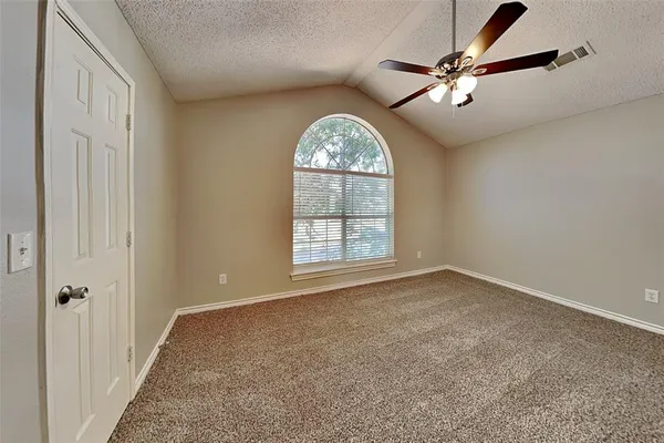 an empty room with windows and fan