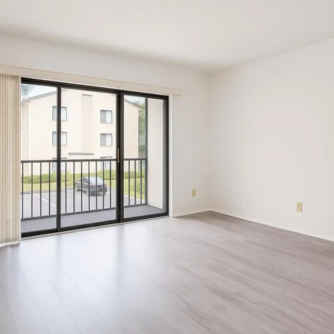 a view of a big room with wooden floor and windows