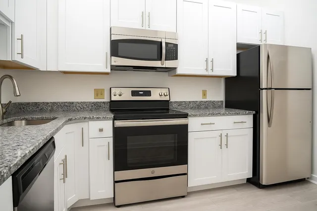 a kitchen with cabinets stainless steel appliances and a sink