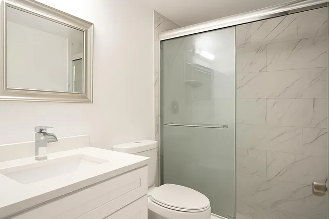 a bathroom with a sink a toilet and shower