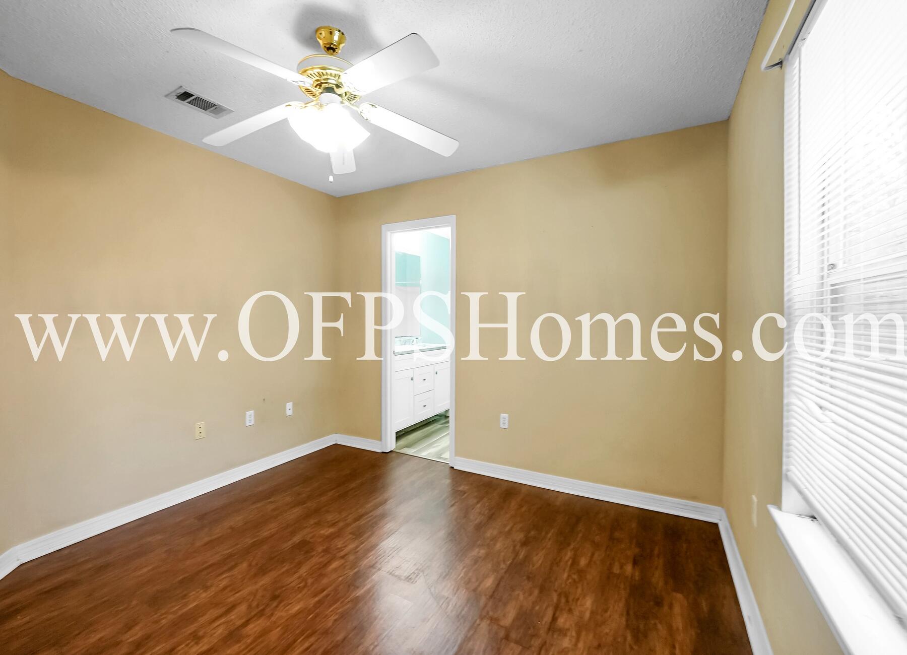 2953 Sholtz Avenue Crestview, FL 32539 - Photo 17 of 33 a view of an empty room with window and wooden floor