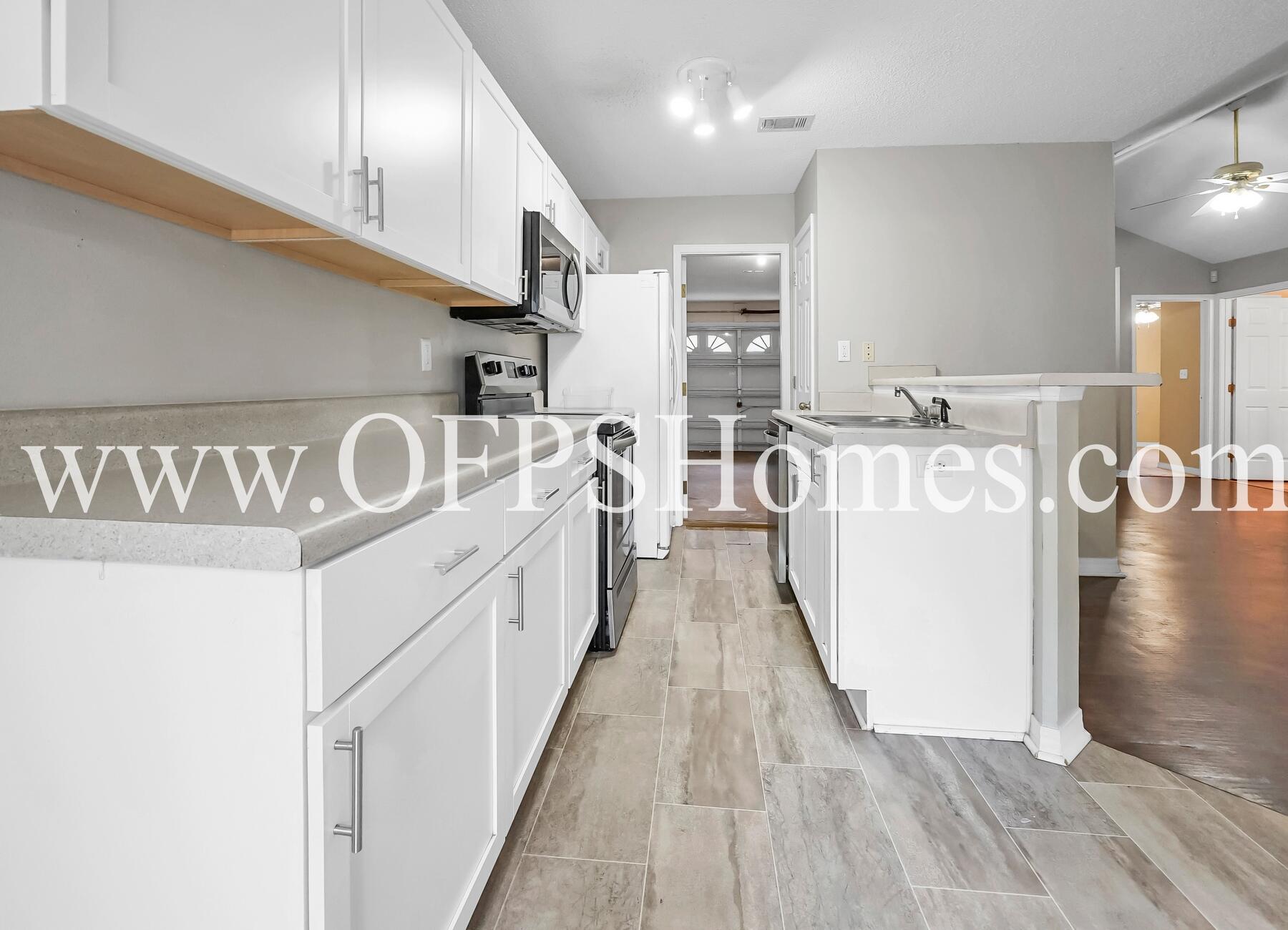2953 Sholtz Avenue Crestview, FL 32539 - Photo 20 of 33 a view of a kitchen with kitchen island stainless steel appliances wooden floor and living room view