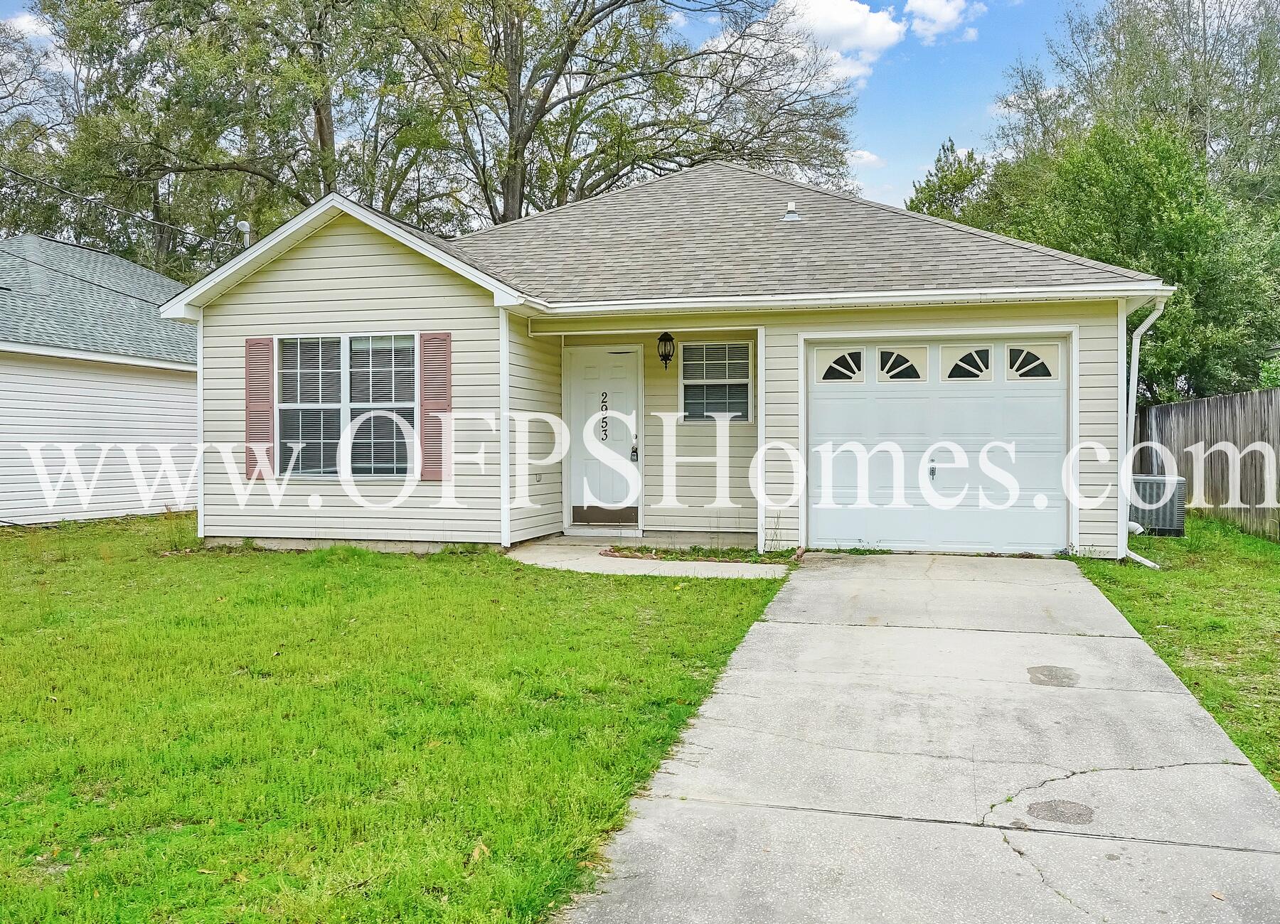 2953 Sholtz Avenue Crestview, FL 32539 - Photo 3 of 33 a front view of a house with a garden and yard