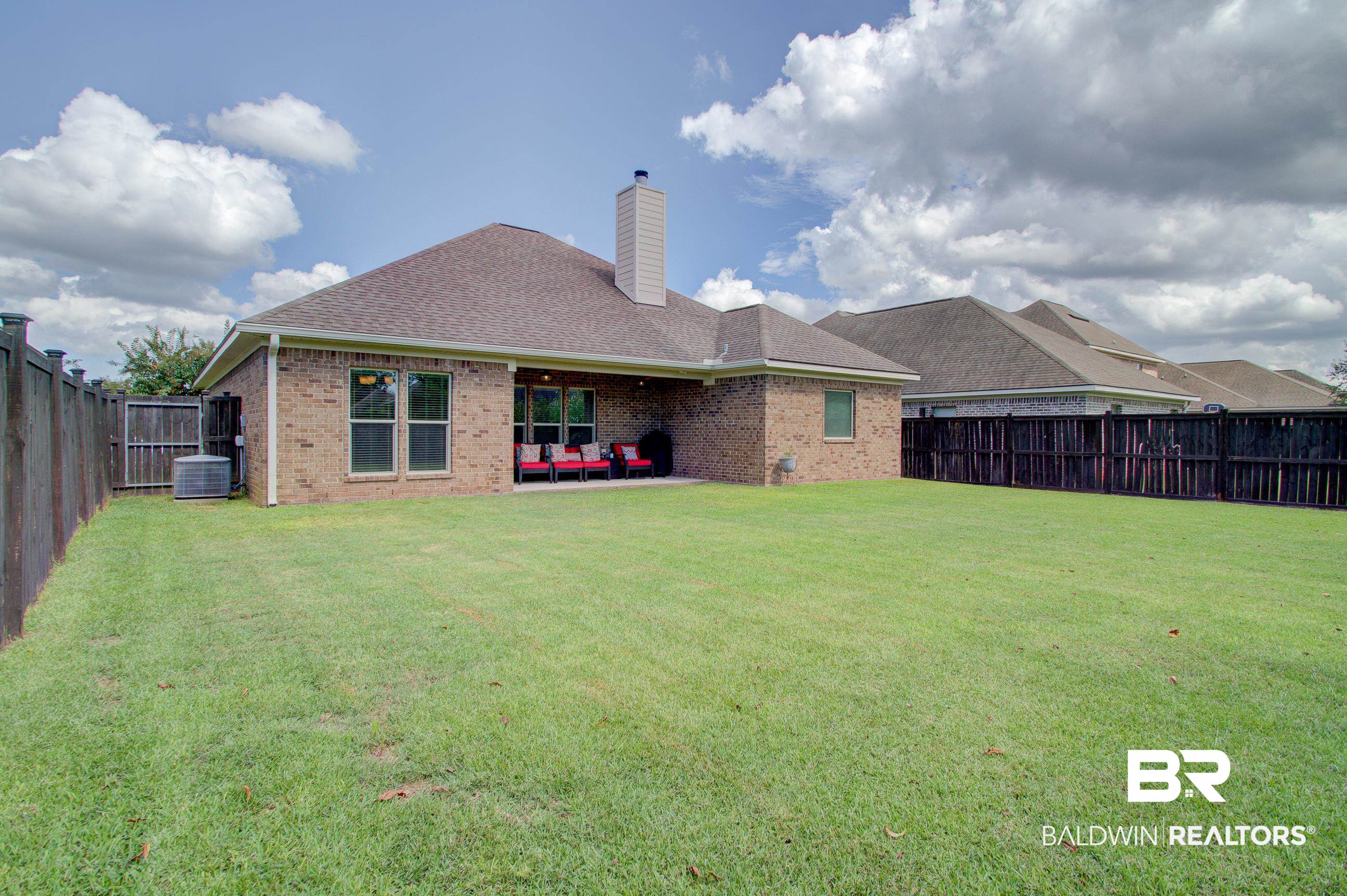 8625 Rosedown Lane Daphne, AL 36526 - Photo 25 of 29 Rear view of house featuring cooling unit, a lawn, and a patio area