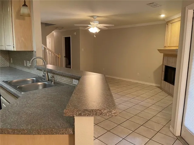 a kitchen with granite countertop a sink a counter top space and cabinets