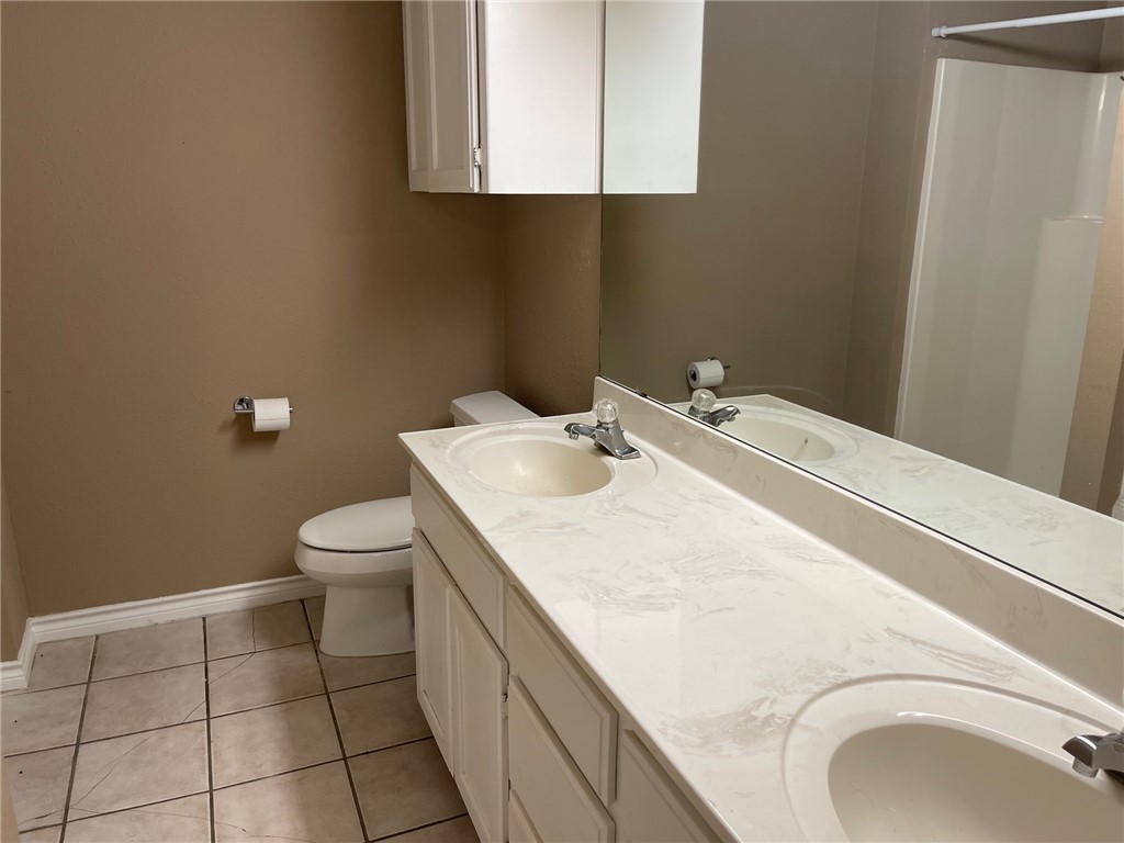 4022 Wood River Drive, Unit 5C Corpus Christi, TX 78410 - Photo 9 of 10 a bathroom with a sink a toilet and a mirror
