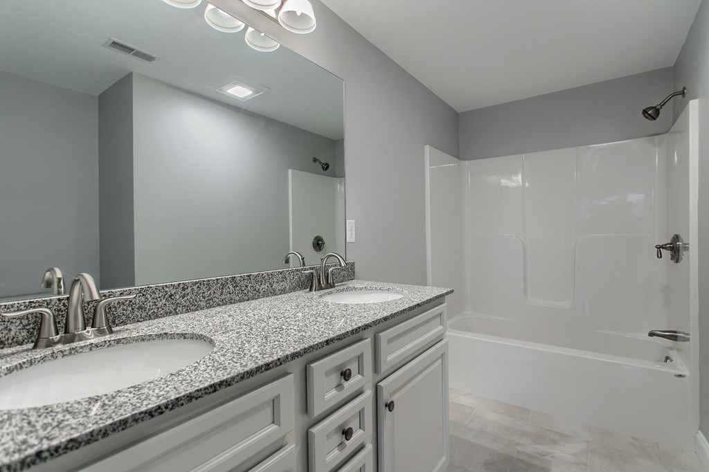 18 Jaclyn's Way, Unit 19 Billerica, MA 01821 - Photo 7 of 16 a bathroom with a granite countertop sink a mirror and a bathtub
