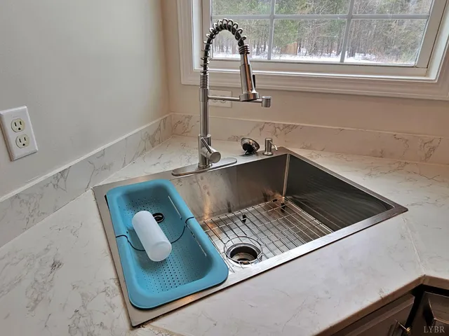 a kitchen with granite countertop a refrigerator stove top oven and sink
