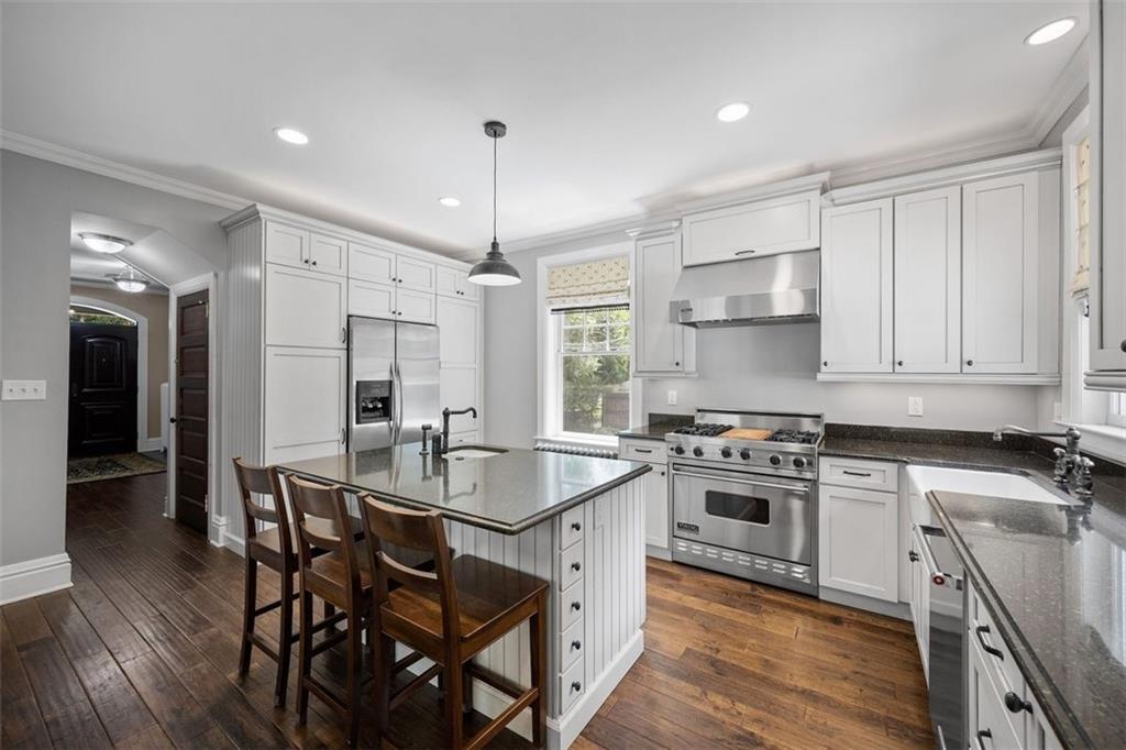 209 Chestnut Road Sewickley, PA 15143 - Photo 32 of 49 a kitchen with stainless steel appliances a stove a sink a refrigerator and white cabinets with wooden floor