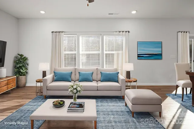 a living room with furniture a rug and a window