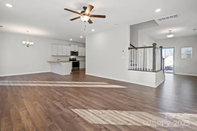 a view of a kitchen with wooden floor and a ceiling fan