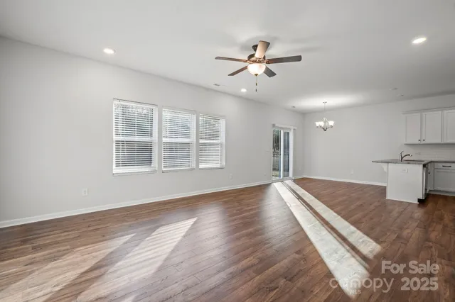 a view of empty room with wooden floor and window