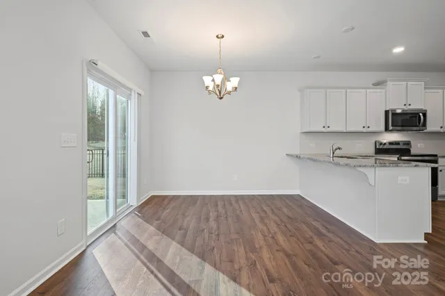 a view of a kitchen with microwave and stove top oven