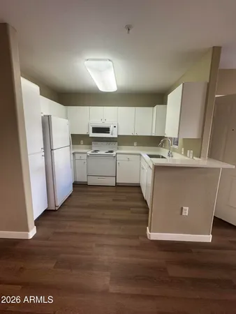 a kitchen with a sink a refrigerator and cabinets