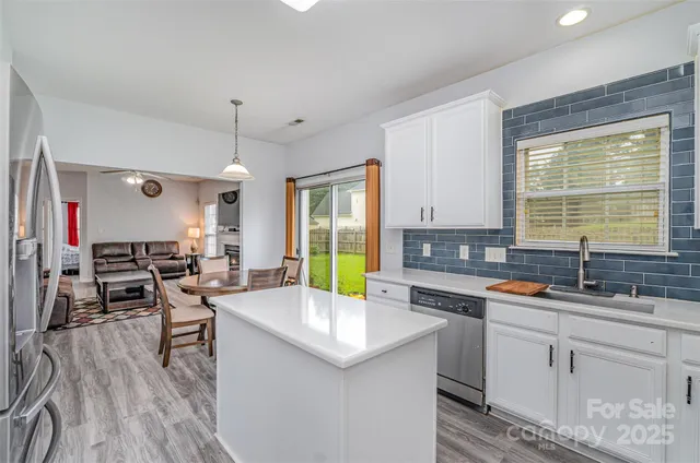 a kitchen with a sink a stove a refrigerator and chairs
