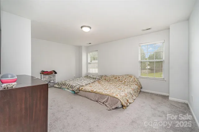 a bed sitting in a bedroom next to a window