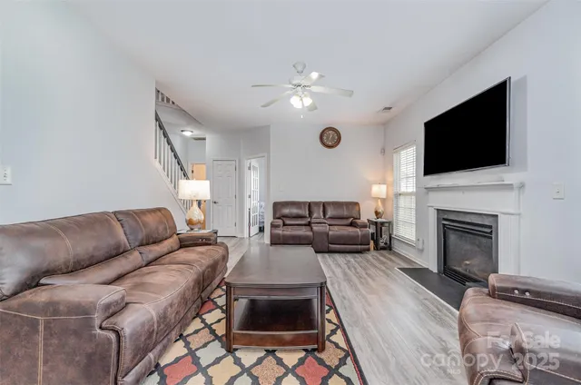 a living room with furniture a fireplace and a flat screen tv